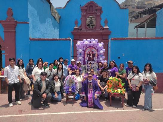 Zu sehen ist ein Gruppenfoto von Gemeindemitgliedern aus unserer Partnergemeinde in Peru. In der Mitte Padre Emerson mit einem blumengeschmückten Andachtsbild